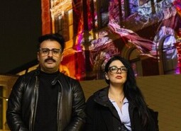 left-right artist Ferdi Alici and Eylul Alici, of OUCHHH, unveil a specially commissioned AI artwork made using cognitive technology to visualise brainwaves of the Arts & Film ‘Game Changers’ and projected across the façade of the V&A’s Exhibition Road Courtyard building in London, as part of The National Lottery’s 30th birthday celebrations.